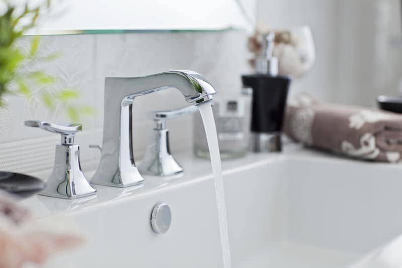 Bathroom faucet with running water. Wasting water and not eco-friendly habit